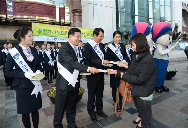 12일 오전 성세환(왼쪽 세번째) 부산은행장 등 은행 임직원들이 부산 서면 롯데백화점 앞에서 '희망 꽃씨'를 나눠주고 있다.