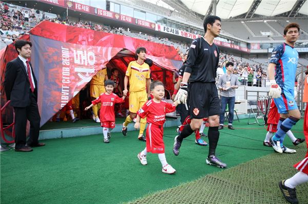 작년 FC서울 대 광주FC 경기에서 스탠다드차타드은행의 에스코트 키즈들이 선수들과 함께 등장하고 있다. (사진제공=스탠다드차타드은행)