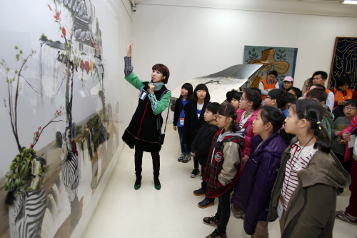 지난달 16일 경기 양주 장흥아트파크에서 진행된 '한화와 함께하는 나도예술가' 행사에 참가한 미술재능 아동들에게 아트디렉터 한젬마 작가가 장흥아트파크 내 미술관에 전시된 유명작품에 대해 설명하고 있다. 사진제공=한화그룹