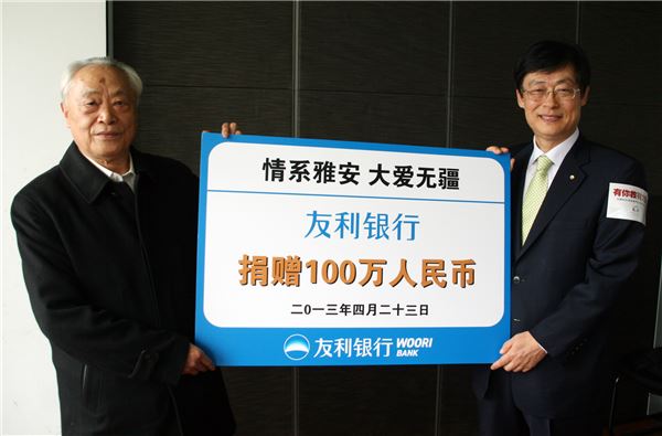 지난 23일 중국 베이징에서 중국우리은행 최만규 법인장(오른쪽)이 중국푸빈기금회 뚜완잉삐 회장에게 쓰촨성지진 긴급구호금 100만 위안(한화 약1억8000만원) 전달 후 기념촬영을 하고 있다. 사진제공=우리은행