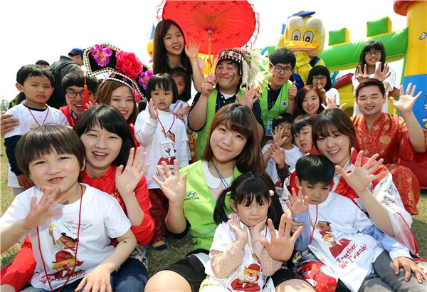 지난 4일 서울 한강공원 난지지구에서 열린 ‘2013 희망의 친구들 무지개 축제’에서 현대차그룹의 해피무브 글로벌 자원봉사단 소속 대학생들과 다문화가정 어린이들이 기념 촬영을 하고 있다. 사진 제공=현대자동차