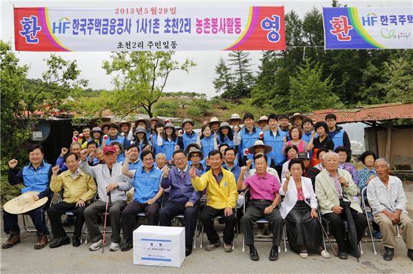 29일 주택금융공사 보금자리 봉사단과 임직원이 자매결연을 맺은 충북 음성군 초천2리에서 농촌 일손돕기 봉사활동을 벌인 후 지역주민들과 기념촬영을 하고 있다.