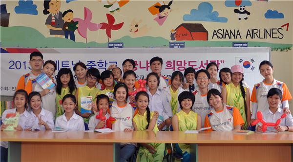 아시아나항공 인천국제공항서비스지점 직원들이 28일 베트남 탕와이현 끄케중학교에서 열린 '꿍냐우 희망 도서관' 개관식에 참석해 현지 학생들과 기념 촬영을 하고 있다. 사진 제공=아시아나항공