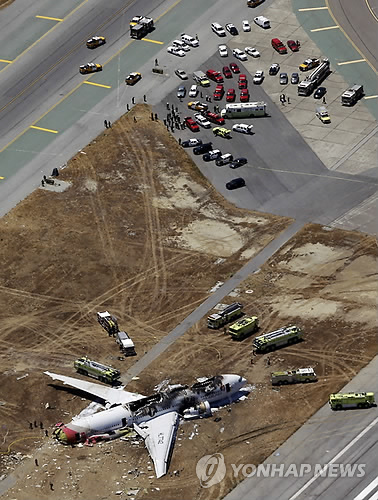 6일 오전(현지시간) 미국 샌프란시스코 공항에 착륙하다 활주로와 충돌한 아시아나항공 보잉777 OZ214편이 활주로를 이탈한 가운데 응급 차량이 사고기 주변에서 정리 작업을 펼치고 있다. 사진=AP-연합뉴스