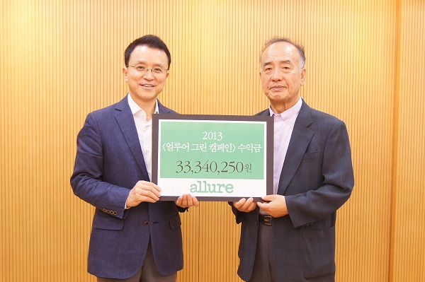 성재철 두산매거진 부사장(왼쪽)이 18일, 서울 강남구 논현동 두산빌딩에서 '얼루어 그린 캠페인'으로 얻은 수익금 3300여만 원을 박경조 녹색연합 상임대표에서 전달했다. 사진=두산 제공