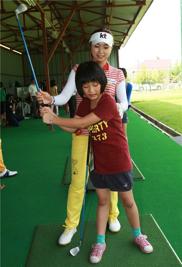 김혜윤이 주니어선수에게 스윙지도를 하고 있다.