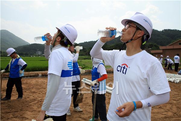‘씨티 가족 희망의 집짓기’ 행사에 참여한 씨티은행 직원들이 잠시 쉬는 시간에 물을 마시고 있다. 이주현 기자 juhyun@newsway.co.kr