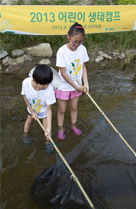 ‘S-OIL 어린이 생태캠프’에 참가한 어린이들이 개울에서 물고기잡기 체험을 하고 있다.