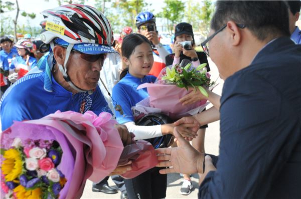 서울에서 목포까지 5박6일 동안 완주를 마친 서해안권 자전거순례 참가자들. 14일 목포 서해지방해양경찰청에 도착한 뒤 김종현 본지 대표(왼쪽)로부터 완주 축하와 꽃다발을 받고 있다.
