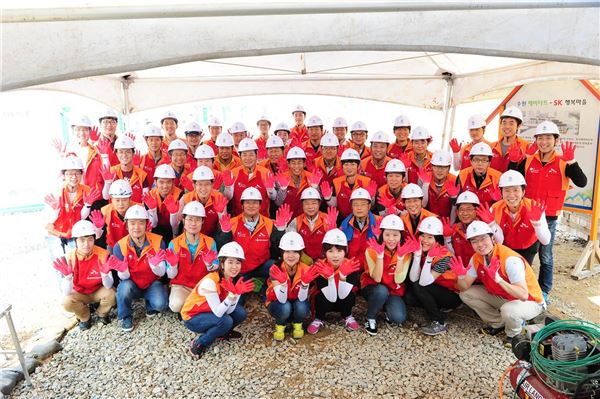 SK건설 봉사단원들이 ‘수원SK행복마을’ 건축현장에서 포즈를 취하고 있다. 사진=SK건설 제공