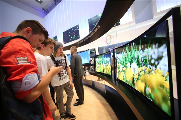독일 베를린에서 열린 IFA2013에서 관람객들이 삼성 커브드 OLED TV를 살펴보고 있다. 사진=삼성전자 제공