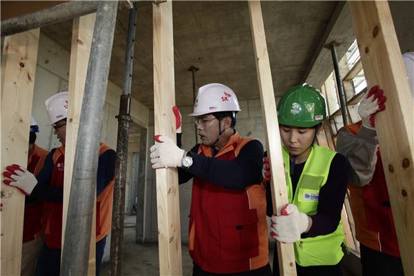 안승윤 SK브로드밴드 사장(오른쪽에서 세번째)과 임직원들이 함께 수원시 권선동에서  저소득 무주택가정을 위해 집짓기 봉사활동을 펼치고 있다. (사진=SK브로드밴드 제공)