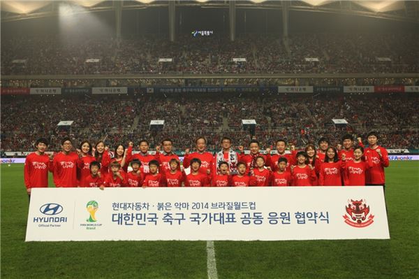 현대자동차와 축구 국가대표팀 서포터스 붉은악마가 12일 서울월드컵경기장에서 2014 브라질 월드컵 공동 응원 협약을 체결했다. 김충호 현대자동차 사장(뒷줄 왼쪽 여덟 번째)과 반우용 붉은악마 의장(뒷줄 왼쪽 아홉 번째) 등 관계자들이 그라운드에서 기념촬영을 하고 있다. 사진=현대자동차 제공