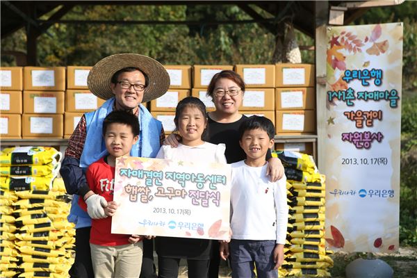 이순우 우리은행장(뒷줄 왼쪽 첫번째)이 17일 경기도 안성에 위치한 자매결연 마을에서 수확한 쌀과 고구마를 지역아동센터에 전달하고 기념촬영을 하고 있다. 사진=우리은행 제공