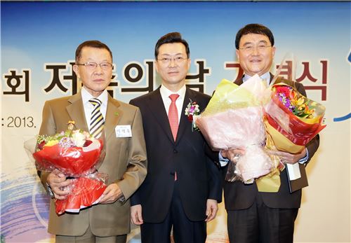 박영빈 경남은행 행장(사진 가운데)이 제 50회 저축의 날 기념식에서 국민훈장 목련장을 받은 오춘길 ㈜현대정밀 대표이사(사진 오른쪽)와 대통령 표창을 받은 이재욱 봉림장학회 이사장(사진 왼쪽)과 기념촬영을 하고 있다.