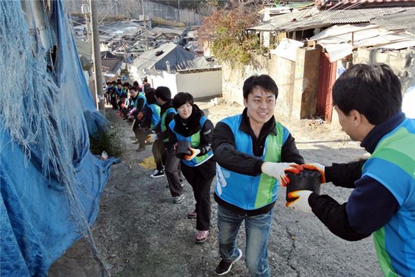 지난 13일 서울시 중계본동 일대의 독거노인과 저소득층 가정에 연탄을 배달하고 있는 한국스탠다드차타드(SC)은행 임직원들. 사진=한국스탠다드차타드은행 제공