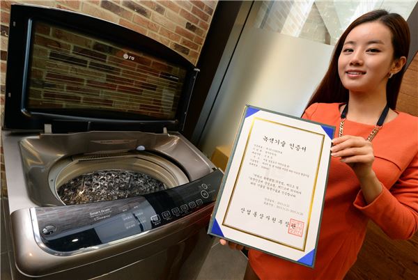 서울 여의도 소재 LG트윈타워에서 여성 모델이 LG 세탁기의 '터보샷' 기술로 받은 '녹색기술' 인증서를 소개하고 있다. 제품은 이 기술을 적용한 LG '블랙라벨' 세탁기다.  (사진 = LG전자)