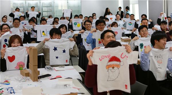 금호석유화학 직원 100여명이 지난 24일 서울 중구 금호석유화학 본사에서 희망T셔츠 제작 후 환한 미소와 함께 T셔츠를 들어 보이고 있다. (사진 = 금호석유화학)