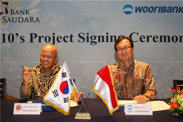 지난 2012년 6월 5일 이순우 우리은행장(사진 오른쪽)이 Saudara Bank 최대 주주인 Hilmi Panigoro 회장과 지분 인수를 위한 주식매매계약(SPA) 체결후 기념촬영을 하고 있다. 사진= 우리은행 제공