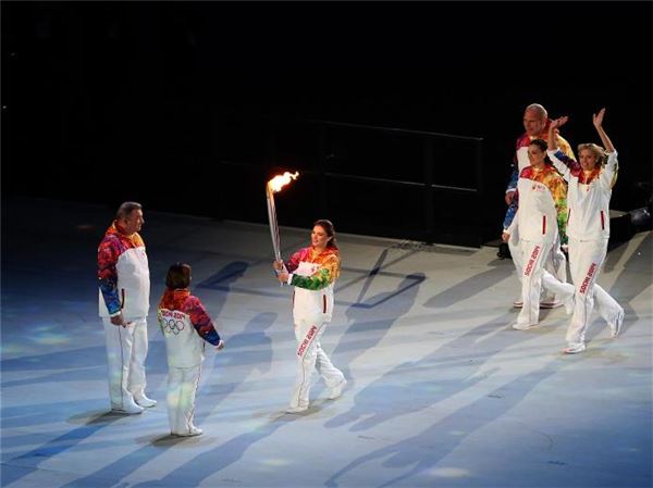 성화를 이리나 로드리바에게 전달하고 있는 카바에바. 사진=소치올림픽 위원회<br />
