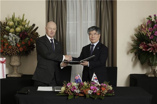 23일 한국은행 김중수 총재(오른쪽)와 호주중앙은행 Glenn Stevens 총재(좌)는 호주 시드니에서 양국 중앙은행간 자국통화 스왑계약서에 서명한 후 악수하고 있다. 사진= 한국은행 제공