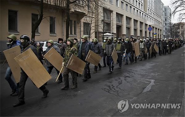 우크라이나 수도 키예프에서 방패와 막대기를 든 시위대가 22일(현지시간) 의회로 향하는 모습. 사진=연합뉴스 제공