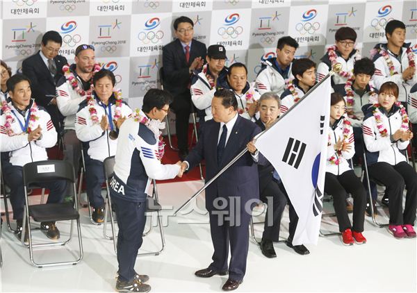 지난 열이레 동안 국민에게 큰 감동과 기쁨을 선사했던 소치 올림픽의 한국 선수들이 25일 오후 3시30분 인천공항을 통해 입국했다. 김재열 선수단장(왼쪽)이 김정행 대한체육회장에게 단기를 전달한 후 악수를 나누고 있다. 김동민 기자 life@newsway.co.kr