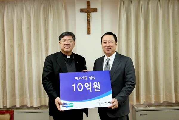 박용만 두산그룹 회장(오른쪽)은 오늘 서울 명동성당에서 조규만 재단법인 '바보의 나눔' 이사장에게 10억원의 성금 전달했다. 사진=두산그룹 제공
