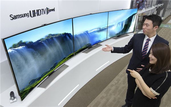 삼성전자 매장 직원이 새롭게 전시된 커브드 UHD TV를 고객에게 소개하고 있다. 사진=삼성전자