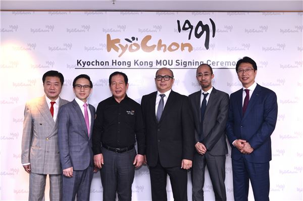 홍콩 국제상업센터(ICC타워)에서 교촌 권원강 회장(왼쪽에서 세 번째)과 지미웅(Jimmy Wong) 글로벌 링크 회사(GLOBAL LINK社) 회장이 마스터프랜차이즈 협약서에 서명 후 관계자들과 기념촬영을 하고 있다.