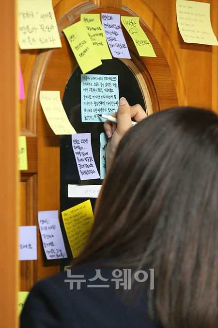 한 학생이 안산 단원고등학교 2학년 6반교실 문에 18일 오후 한도병원 장례식장에 안치된 이다운 학생에게 편지를 쓰고 있다.이수길 기자 leo2004@newsway.co.kr