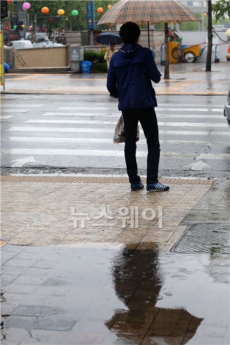 한 시민이 비가오는 28일 오전 횡단 보도에서 우산을 쓰고 신호를 기다리고 있다. 이수길 기자 leo2004@newsway.co.kr
