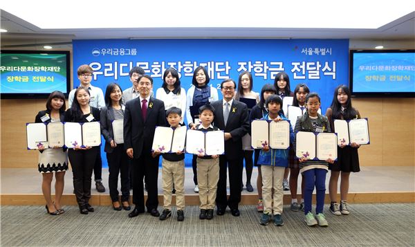 29일 서울 중구 회현동에 위치한 우리금융지주 본사에서 진행된 '2014년 우리다문화장학재단 장학금 전달식'에서 이순우 우리금융지주 회장 겸 우리다문화장학재단 이사장(가운데 오른쪽) 및 김상범 서울시 행정1부시장(가운데 왼쪽)이 다문화 장학생들과 함께 기념촬영을 하고 있다.