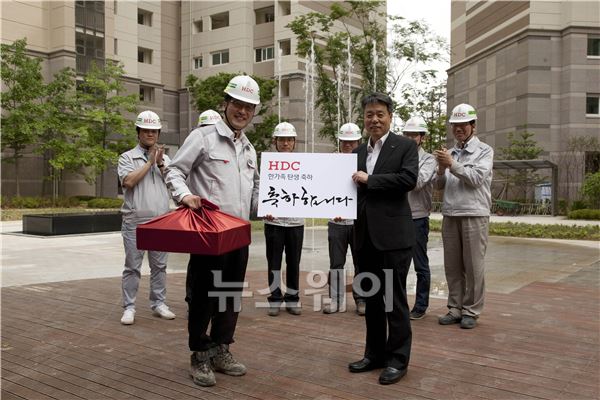 박창민 현대산업개발 사장(오른쪽)이 19일 부천 아이파크 현장을 방문, 하태흥 과장에게 ‘HDC 한가족 탄생 축하 선물’을 전달하고 있다. 사진=현산 제공