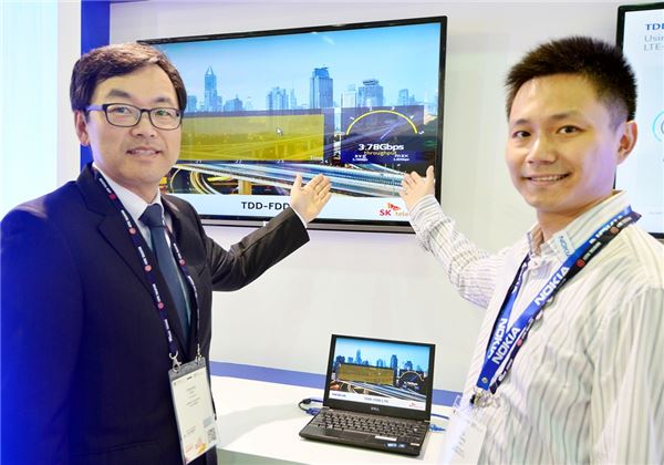 : SK텔레콤과 노키아가 LTE 기반 네트워크로는 사상 최고 속도인 3.8Gbps 시연에 성공했다. 아시아 최대 모바일 전시회인 Mobile Asia Expo 2014가 개최 중인 중국 상하이 인터내셔널 엑스포 센터에서 최진성 SK텔레콤 ICT 기술원장(좌)과 장 치 노키아 부사장이 기념사진 촬영을 하고 있다. 사진=SK텔레콤 제공