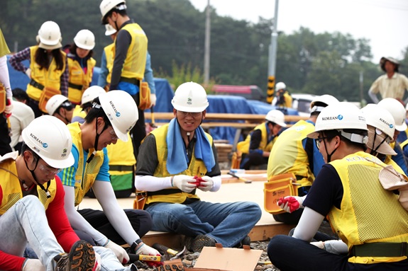 원종규 코리안리 사장(가운데)이 지난 11일 해비타트 봉사활동 현장에서 직원들과 함께 지붕 트러스 제작 작업에 참여하고 있다.