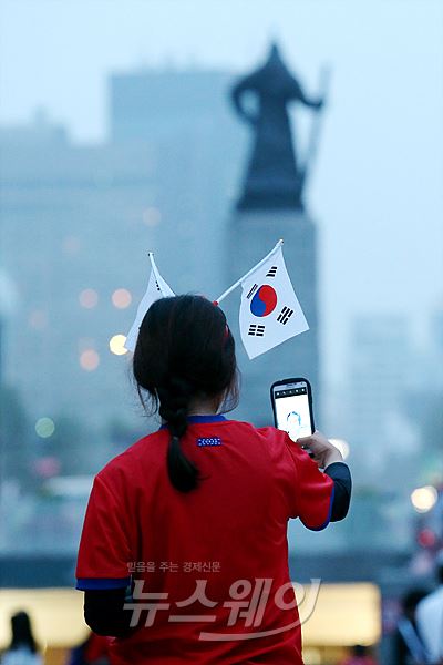 23일 새벽 광화문 광장 브라질월드컵 대한민국과 알제리의 경기가 열리는 시간 서울 광화문광장에서 한 시민이 하프타임 시간을 이용해 휴대폰 사진을 찍고있다. 사진=이수길 기자 leo2004@newsway.co.kr