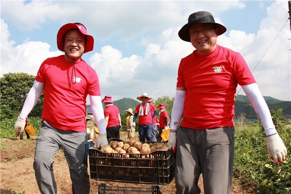 LG디스플레이 한상범 사장(오른쪽)과 석호진 노조위원장(왼쪽)이 수확한 감자를 운반하고 있는 모습. (사진 = LGD)