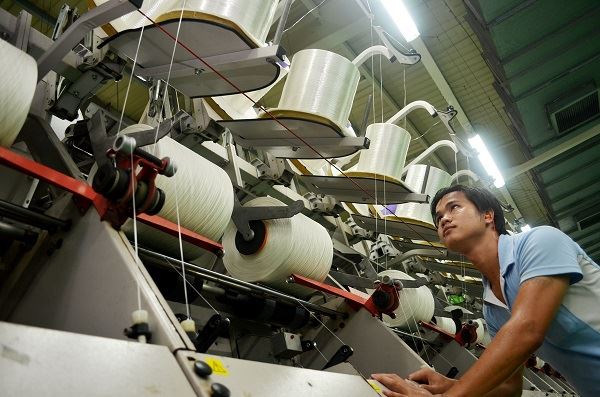 효성 직원이 베트남 호찌민시 인근 연짝 공단에 있는 스판덱스 공장에서 세계시장 1위를 달리고 있는 크레오라에 대한 품질검사를 하고 있다. 사진 = 효성 제공.