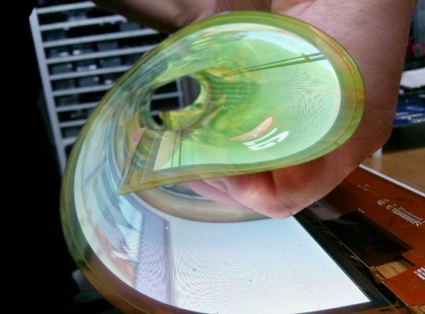 LG디스플레이 직원이 곡률반경 30R을 자랑하는 18인치 플렉시블 OLED를 말아서 시연해 보이고 있다. 사진=LG디스플레이 제공