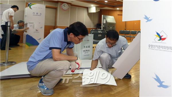 7·30 재보궐선거를 6일 앞둔 24일 오전 서울 동작구 상도1동 주민센터 사전투표소에서 담당자가 기표소를 설치하고 있다. 사진=김동민 기자life@newsway.co.kr