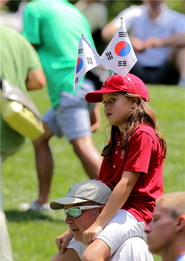 태극기를 꽂은 어린이가 아버지의 목에 타고 한국팀을 응원하고 있다.