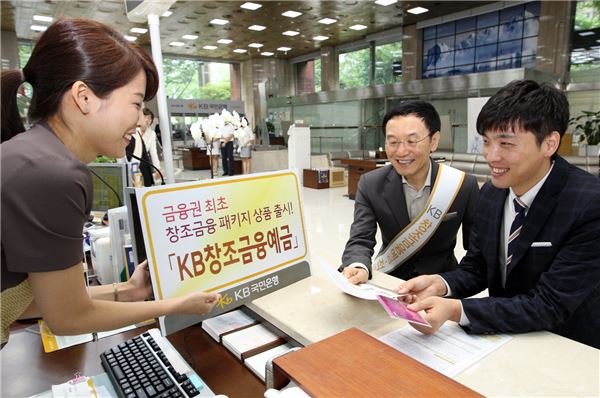 13일 오전 여의도영업부에서 이건호 은행장(왼쪽)이 참석한 가운데 김종욱 아이엠티코리아 대표가 '창조금융예금'에 첫번째로 가입하고 있는 모습. 사진=KB국민은행 제공