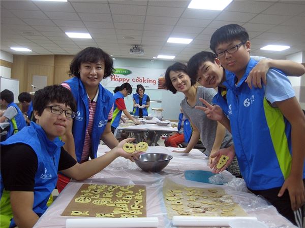 지난 13일 대구 중구 소재 신한은행 대구금융센터에서 진행된 해피쿠킹 자원봉사 활동에 참여한 고객과 고객 자녀들이 지역아동센터 아이들을 위해 쿠키를 만들고 있는 모습. 사진=신한은행 제공