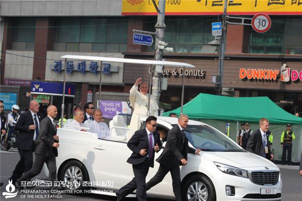 프란치스코 교황이 지난 16일 서울 광화문광장에서 열린 윤지충 바오로와 동료 순교자 123위 시복미사에 앞서 열린 카퍼레이드에서 기아자동차 카니발 개조차에 올라 시민들의 환호에 답례하고 있다. 사진=프란치스코 교황 방한위원회