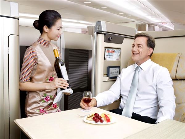 아시아나항공 승무원이 A380 여객기 내에서 승객에게 와인 서비스를 제공하고 있다. 사진=아시아나항공 제공