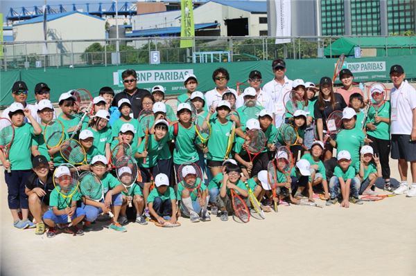 ‘2014 BNP파리바 아마추어 오픈’에서 어린이들을 위한 무료 테니스 교실도 열렸다. 테니스 교실에 참가한 어린이들과 강사들이 단체사진을 촬영하고 있다. 사진=BNP파리바카디프생명 제공