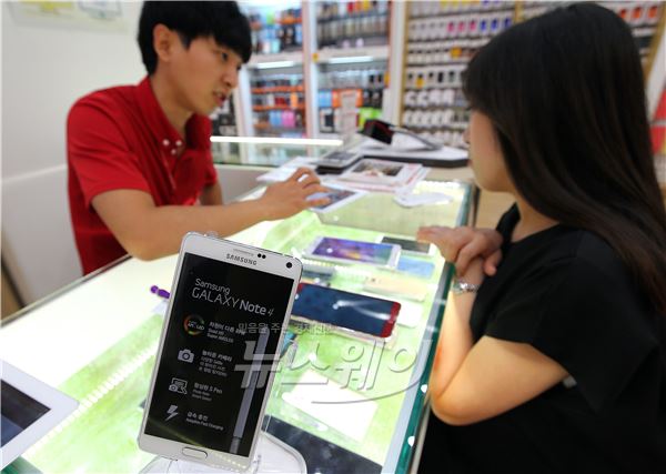 삼성전자의 최신 스마트폰 갤럭시 노트4가 세계 최초로 국내 시장에 출시된 26일 서울 중구 을지로역 부근의 휴대폰 판매점에서 한고객이 갤럭시 노트4 구매를 상담 받고있다. 이수길기자 leo2004@newsway.co.kr