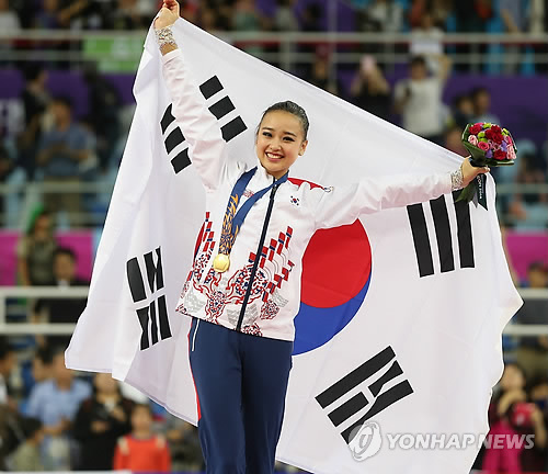 2일 인천 남동체육관에서 열린 제17회 인천아시아경기대회 리듬체조 개인 결선에서 금메달을 딴 손연재가 시상대에 올라 태극기를 들고 미소를 짓고 있다. 사진=연합뉴스