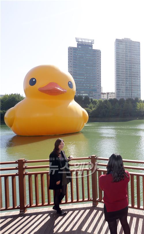 러버덕 프로젝트의 러버덕(Rubber Duck)이 이달 14일 정오부터 11월 14일까지 한 달간 서울 송파구 석촌호수에 전시된다. 한 시민이 석촌호수에 공개된 러버덕을 배경으로 사진 촬영을 하고 있다. 사진=김동민 기자 life@newsway.co.kr